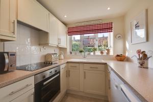 a large kitchen with white cabinets and a window at 2 Bed in Holt oc-2195 in Holt