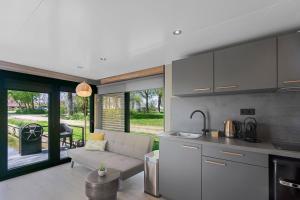 a kitchen and living room with a couch and a table at Houseboats Pean-buiten Weidum in Weidum