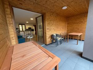 a patio with a wooden table and chairs in a room at Forest House Buxusson in Dolní Slověnice