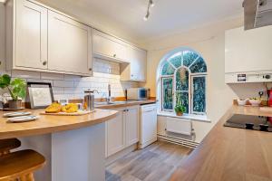 a kitchen with white cabinets and a large window at 1 Bed in Wymondham oc-w30597 in Wymondham