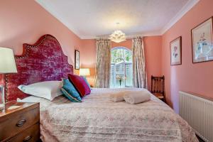 a bedroom with a large bed with pink walls at 1 Bed in Wymondham oc-w30597 in Wymondham