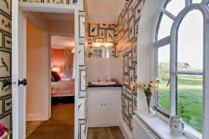 a bathroom with a window and a room with a bed at 1 Bed in Wymondham oc-w30597 in Wymondham +4 photos