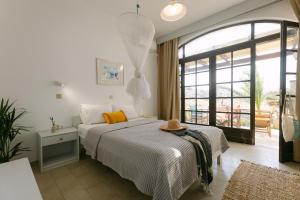 a bedroom with a bed and a large window at Victoria Studios & Apartments in Mikri Vigla