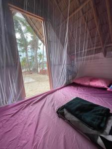 a bed in a tent with a pink sheet at Island Crib in El Nido +46 photos