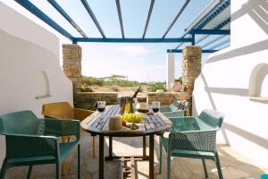 a table and chairs on a patio with wine glasses at Victoria Studios & Apartments in Mikri Vigla