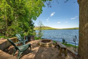 a patio with a fire pit next to a lake at AAH Chalet by Railey Vacations in Oakland