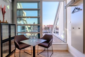 a balcony with two chairs and a table and windows at Quartier E in Naumburg