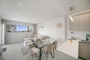 a white living room with a table and chairs at Calpe Silver Tower 5B in Calpe