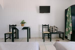 a room with two chairs and a table and a tv at Victoria Studios & Apartments in Mikri Vigla