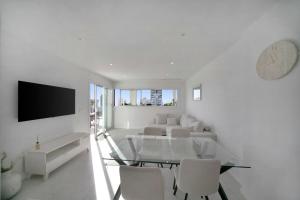 a white living room with a glass table and chairs at Calpe Silver Tower 5B in Calpe