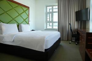 a hotel room with a large bed and a television at Holyland Hotel Amman in Amman