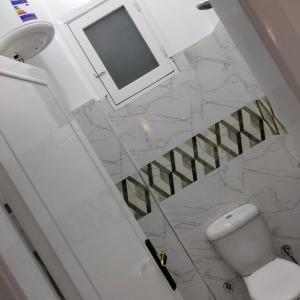 a white bathroom with a toilet and a mirror at Diamond in Luxor