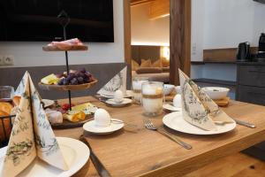 a table with plates of food and a bowl of fruit at Alpenapart Schmid in Niederthai