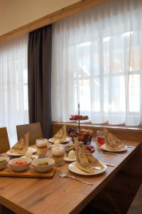 a wooden table with plates and bowls of food on it at Alpenapart Schmid in Niederthai +15 photos