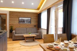 a living room with a couch and a table at Alpenapart Schmid in Niederthai