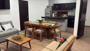 a living room with a table and a kitchen at Mirador 28 in Platanitos