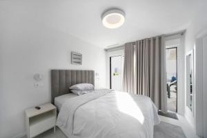a white bedroom with a bed and a window at Calpe Silver Tower 5B in Calpe +13 photos