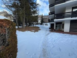 a snow covered driveway in front of a building at Location studio à Serre Chevalier 1350 in Saint-Chaffrey +1 photo