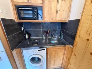 a kitchen with a washing machine and a microwave at Location studio à Serre Chevalier 1350 in Saint-Chaffrey