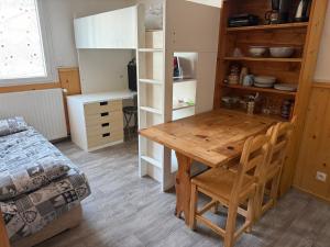 a room with a wooden table and a bed at Location studio à Serre Chevalier 1350 in Saint-Chaffrey