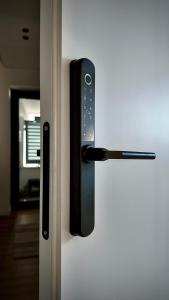 a doorhandle of a refrigerator with a door handle at Fivenco Suites - Private Suites w King Bed Modern in Tirana