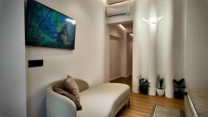 a living room with a couch and a tv on a wall at Fivenco Suites - Private Suites w King Bed Modern in Tirana +72 photos