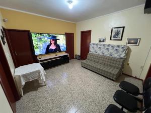 a living room with a flat screen tv and a couch at Casa da lagoa in Imbituba