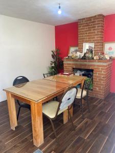 a wooden table and chairs in a room with a fireplace at Casa Ecológica Angangueo in Mineral de Angangueo
