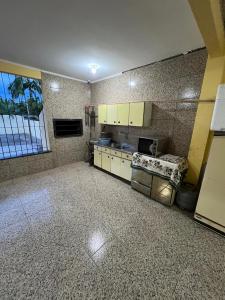 a kitchen with white cabinets and a tile floor at Casa da lagoa in Imbituba
