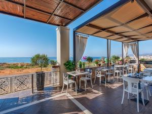 eine Terrasse mit Tischen und Stühlen und dem Meer in der Unterkunft Alexis Hotel in Chania