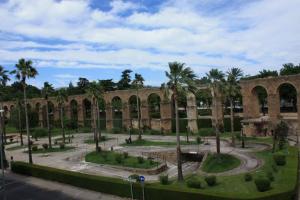 an old building with palm trees and a courtyard at La Capital del Jerte in Plasencia