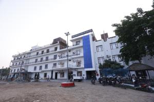 a large white building with motorcycles parked in front of it at New Awadhesh Singh Hotel in Chauri