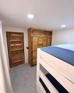 a bedroom with a bed and wooden cabinets and a door at Brianne's Place in Playa hermosa