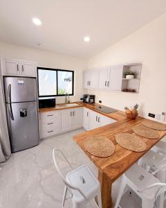 a kitchen with a wooden table and a refrigerator at Brianne's Place in Playa hermosa
