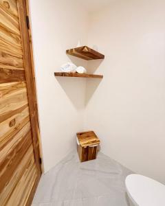 a bathroom with a toilet and a wooden shelf at Brianne's Place in Playa hermosa +6 photos