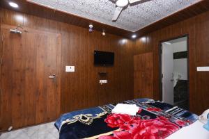 a bedroom with wooden walls and a bed with red flowers on it at New Awadhesh Singh Hotel in Chauri