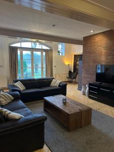a living room with couches and a coffee table at Huize Kroezzz sfeervolle authentieke vakantie woning met 3 slaapkamers, omheinde tuin en honden welkom in Goor