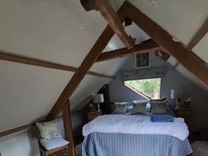 a bedroom with a bed in a attic at The Old Mill Annexe in Jacobstowe