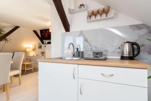 a kitchen with white cabinets and a counter top at Chic Palace - Boutique studio apartment in Vukovar