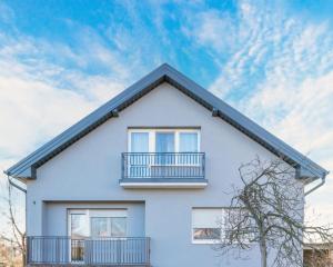 a white house with a balcony and a blue sky at Chic Palace - Boutique studio apartment in Vukovar