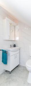 a white bathroom with a sink and a toilet at Chic Palace - Boutique studio apartment in Vukovar +22 photos