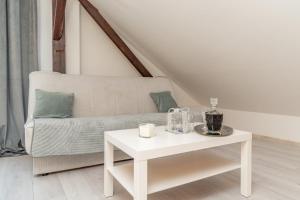 a living room with a white couch and a table at Chic Palace - Boutique studio apartment in Vukovar
