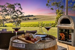 a table with two glasses of wine and a plate of food at Norm's Vineyard Retreat in Lyndoch