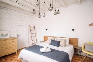 a bedroom with a large white bed and a yellow chair at Serpa Beach House in Matosinhos