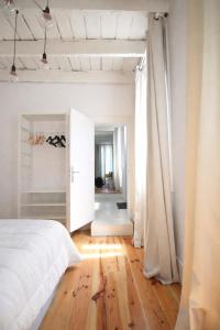 a bedroom with a white bed and a wooden floor at Serpa Beach House in Matosinhos