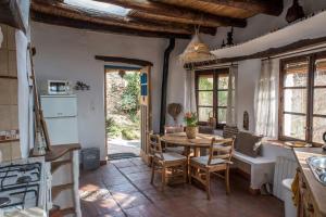 a kitchen and dining room with a table and chairs at Casa Walhalla & Cortijo El Páramo in Pampaneira