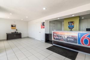 a waiting room with a sign that says well leave the light on for you at Motel 6 Fort Worth, TX - North in Fort Worth