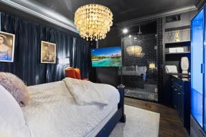 a bedroom with a bed and a tv and a chandelier at Spacious studio condo in historic Munger Place in Dallas