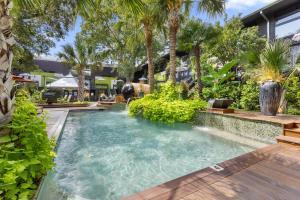 a swimming pool in the middle of a yard with trees at Spacious studio condo in historic Munger Place in Dallas