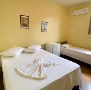 a room with a bed with a white towel on it at Hotel Miracema Palace LTDA in Miracema do Norte